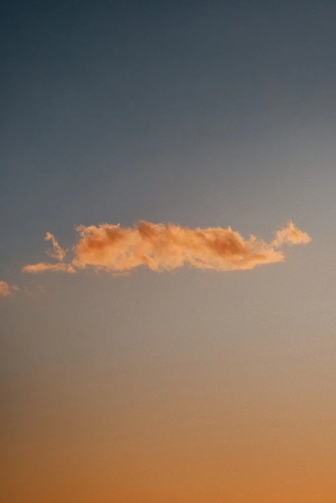 Einzelne orangefarbene Wolke im Abendhimmel