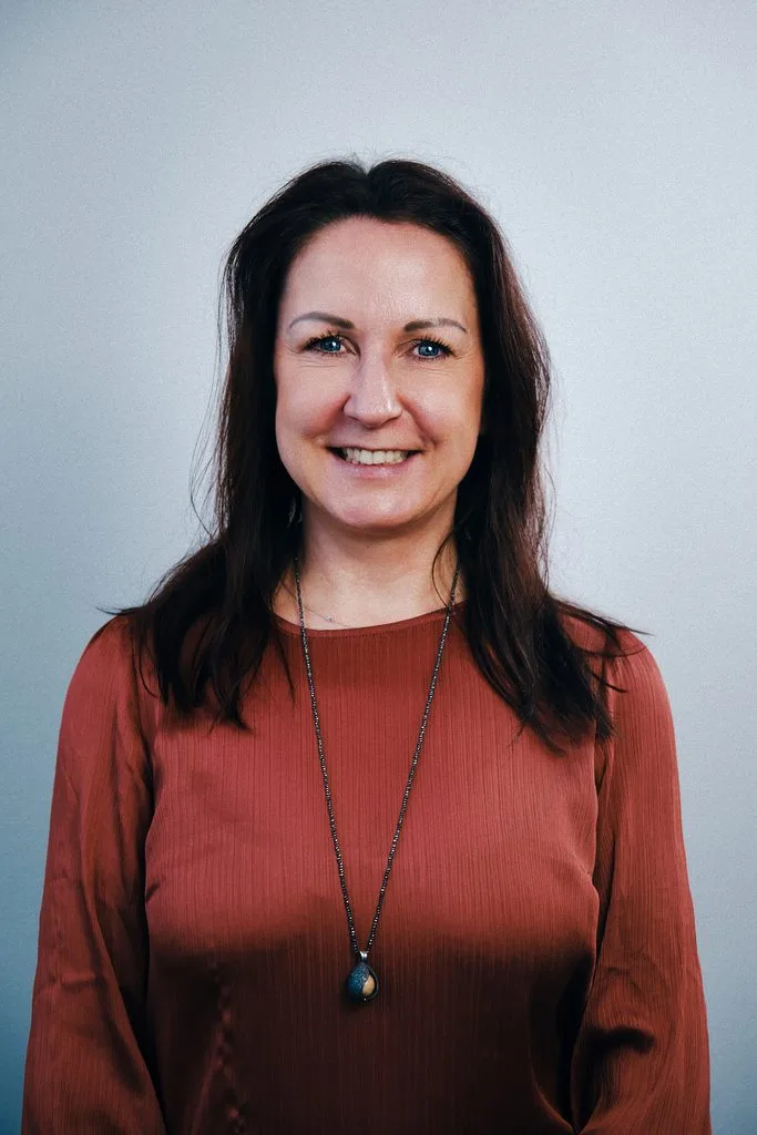 Business-Portrait einer lächelnden Frau vor hellem Hintergrund