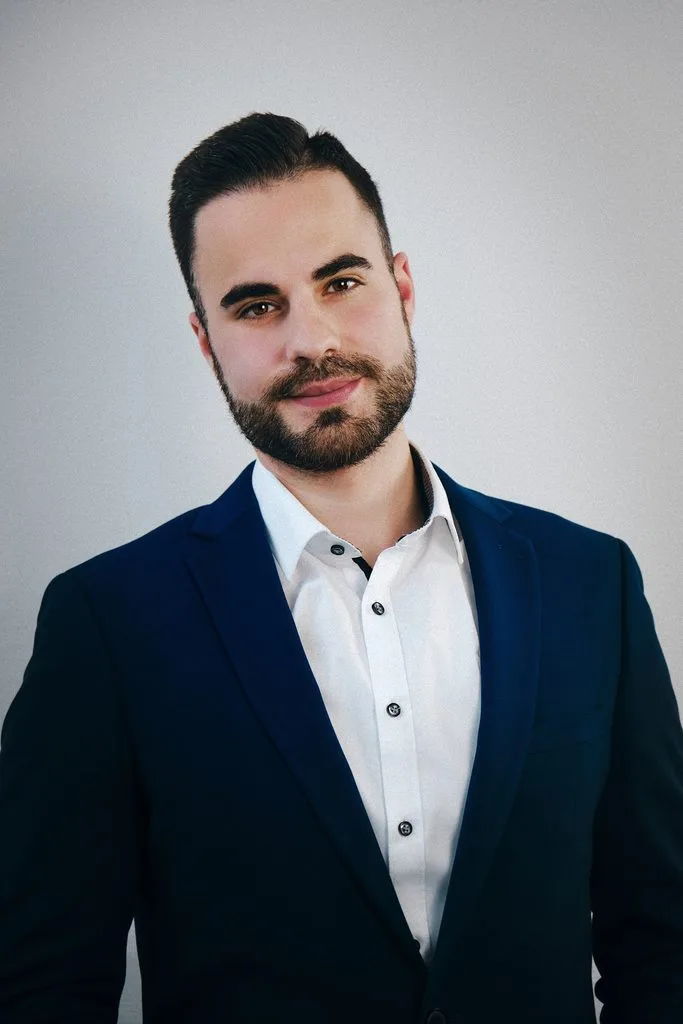 Business-Portrait eines Mannes im Sakko vor hellem Hintergrund