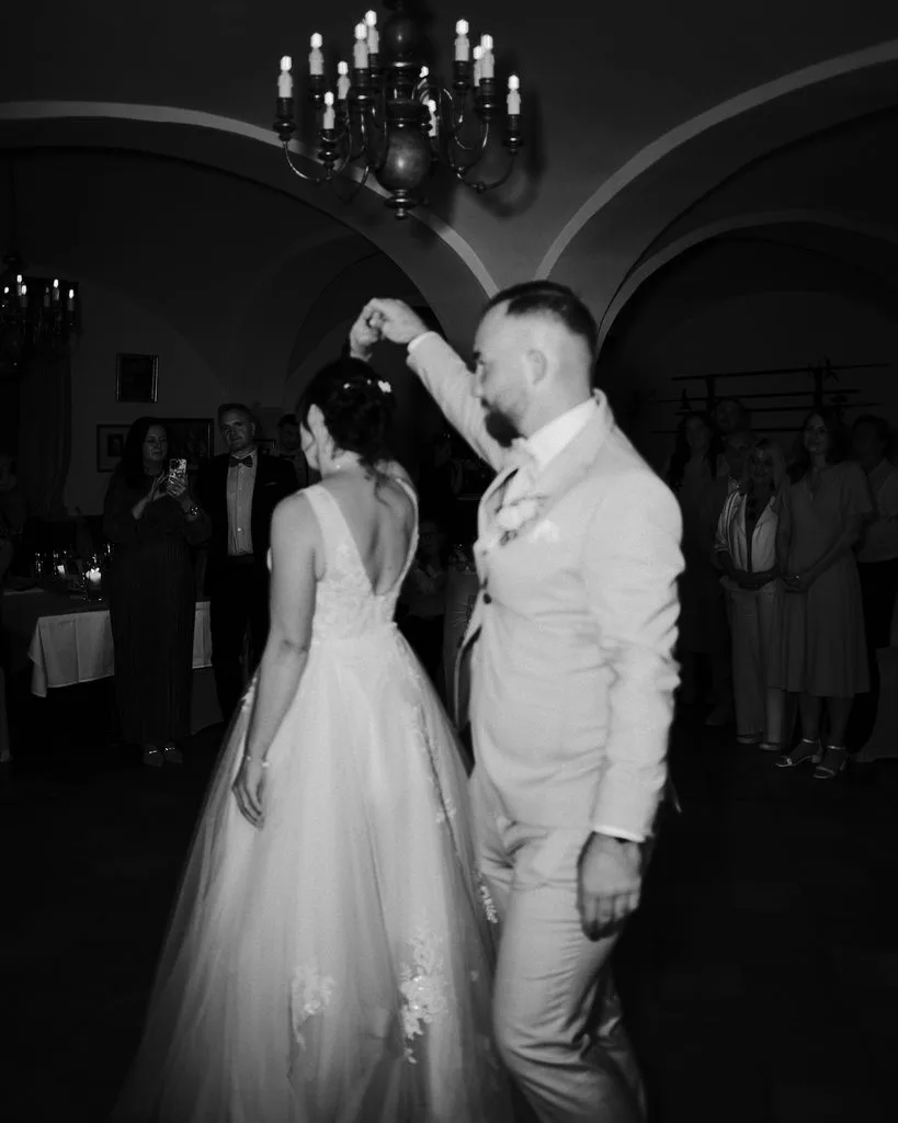 Brautpaar beim Hochzeitstanz unter einem Kronleuchter, Schwarz-Weiß