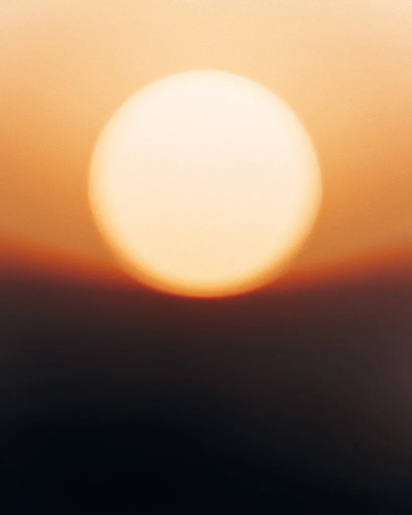 Sonnenuntergang: Die Sonne als großer, weicher Lichtball über dem Horizont