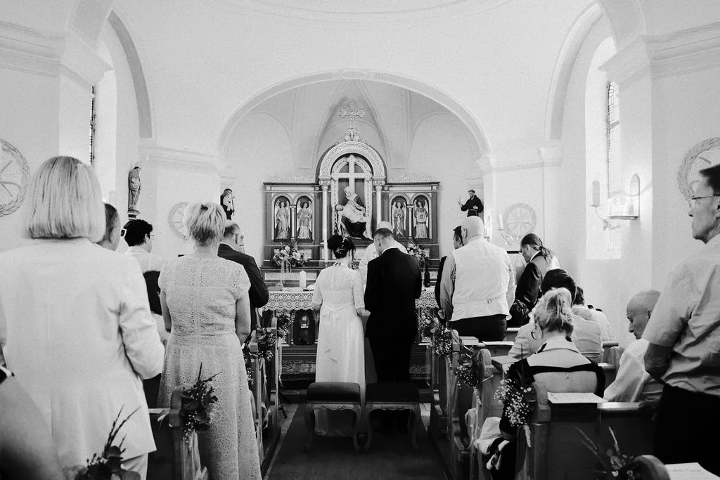 Kirchliche Trauung in der Kapelle Poxau bei Marklkofen: Brautpaar vor dem Altar, Gäste in den Kirchenbänken