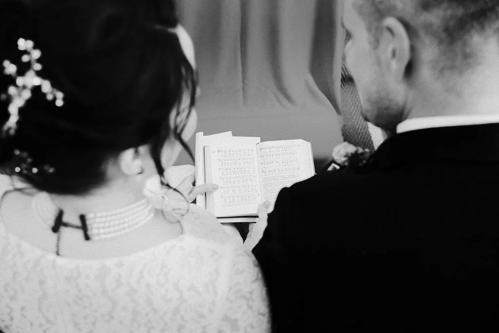 Brautpaar liest bei der kirchlichen Trauung gemeinsam im Gesangbuch